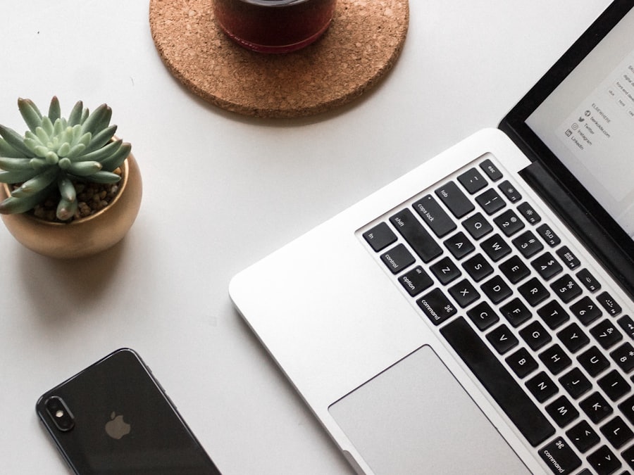 A laptop and phone arranged on a pale desk